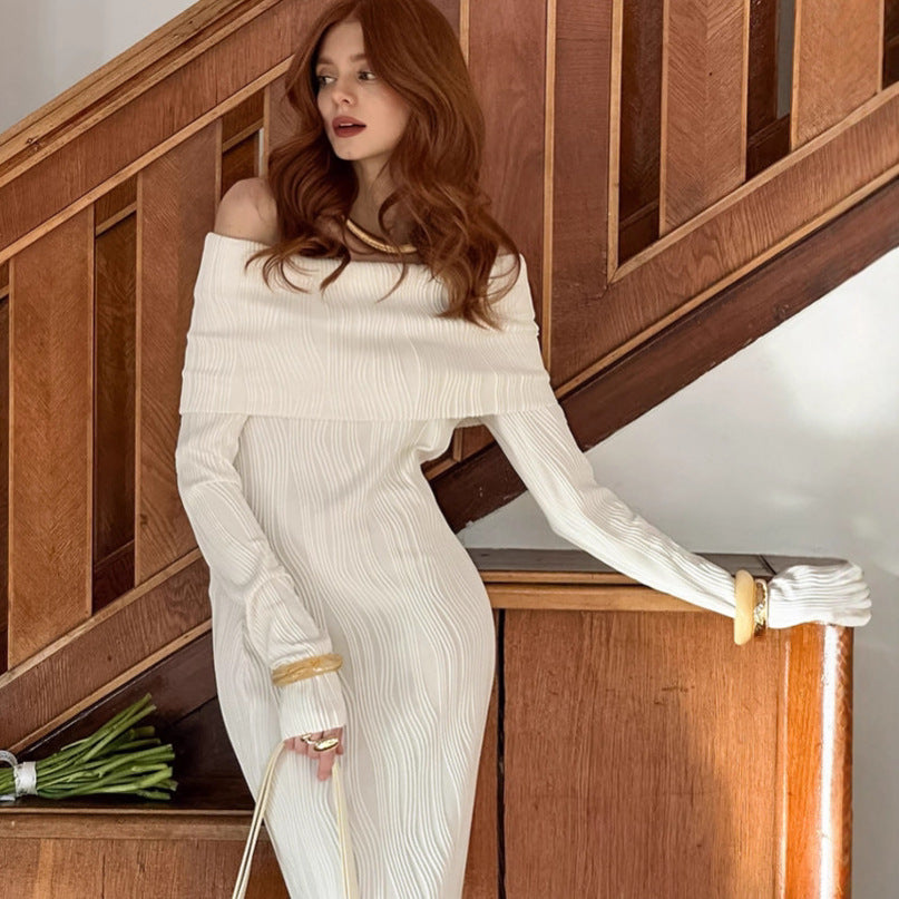 Woman in a fitted off-shoulder knitted dress at an autumn sunset rave, surrounded by glowing lights, accessorized for bold, energetic festival vibes.