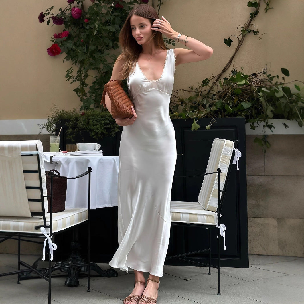 Woman in a French-inspired sleeveless slim dress, posing confidently outdoors in summer sunshine, radiating chic, effortless, festival-ready style.