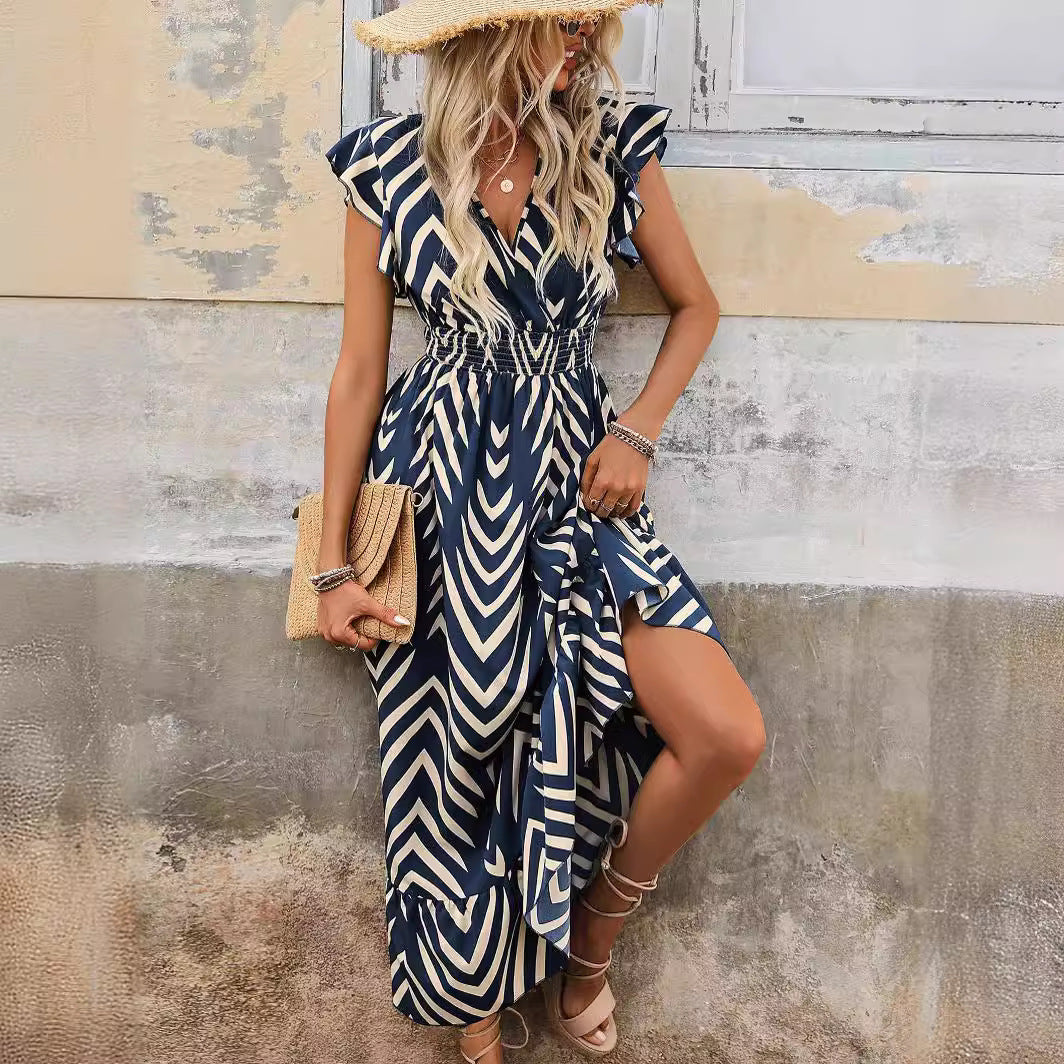 Woman wears a Ragazza printed short sleeve dress with lace-up long hem, standing outdoors in sunlight, radiating summer elegance and confidence.
