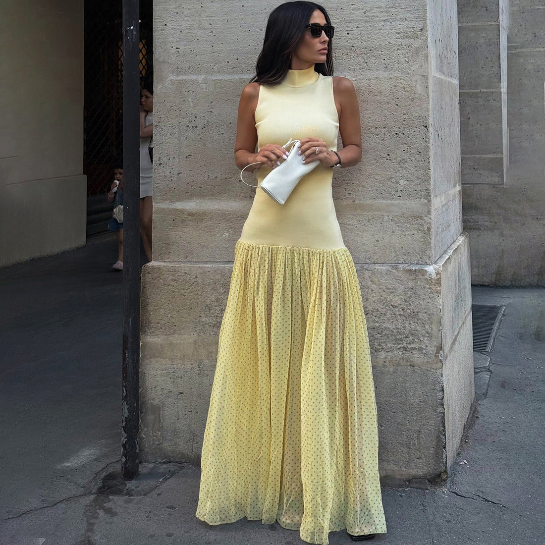 Model in a high collar, slim-fit patchwork polka dot maxi dress radiates festival energy, styled with bold accessories for rave and nightlife vibes.