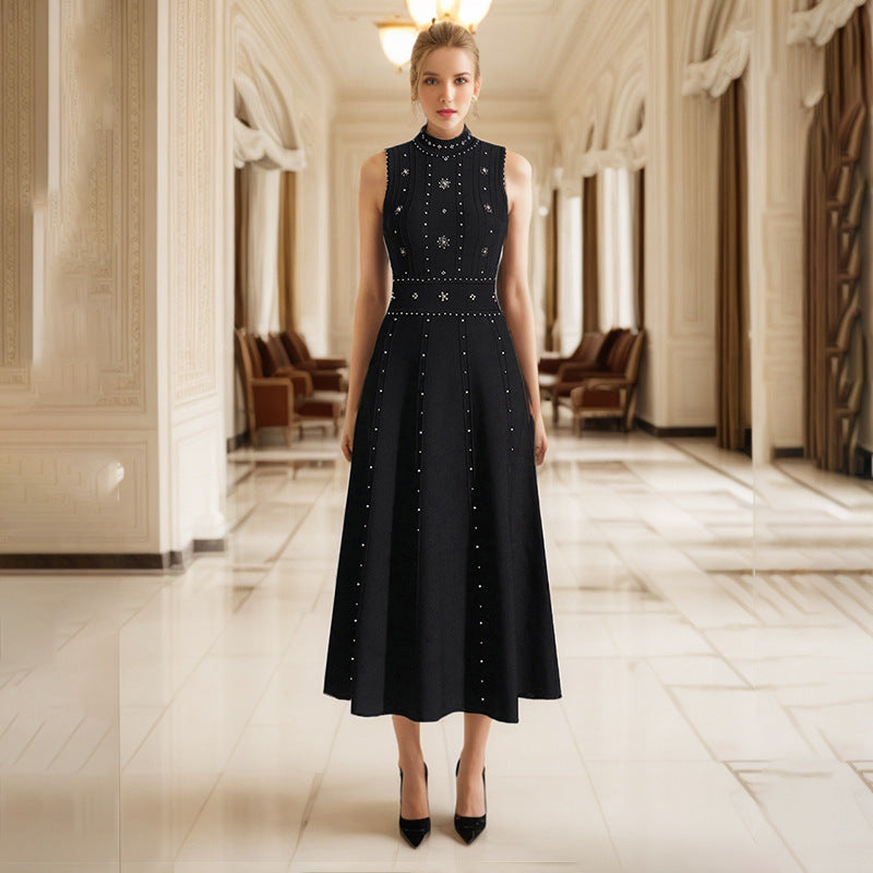 Model in a sleeveless A-line dress adorned with beads and rhinestones, posing confidently at a vibrant spring festival in glowing daylight.